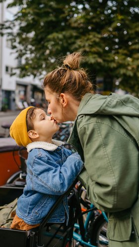 Moeder met kind en bakfiets krijgt verse dadels mee naar school
