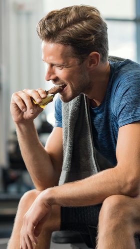 Man eet dadelreep van verse dadels in de gym
